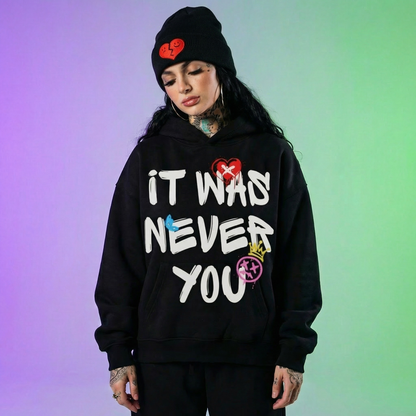 Person wearing a black hoodie with colorful text on a gradient background